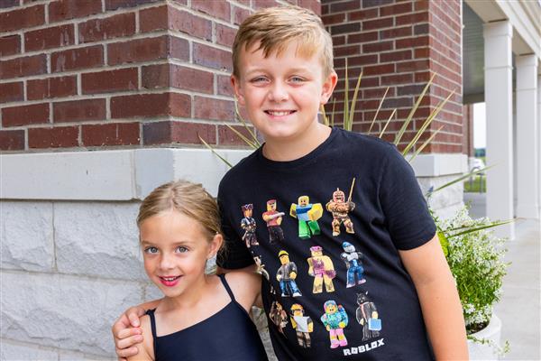 boy and girl smiling in front of school